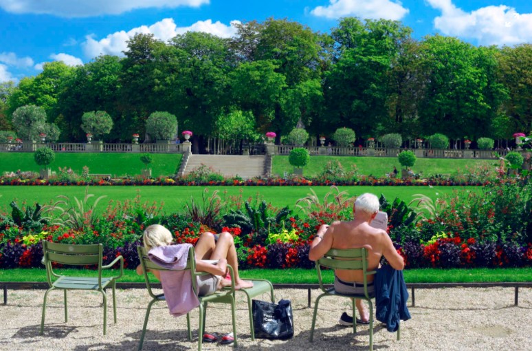 man and woman sitting in front of flowers and beautiful scenery