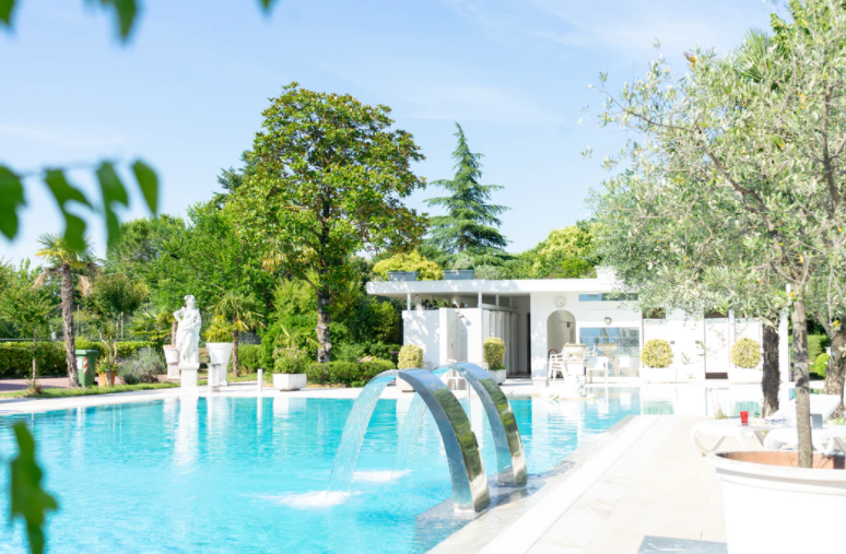 Scupper with water flowing into pool and green trees